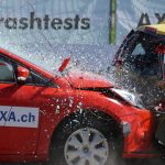 Red and yellow cars shown in a head-on collision during a crash test for safety evaluation.
