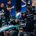 Formula 1 team completes final preparations for the race. High-energy pit crew action.